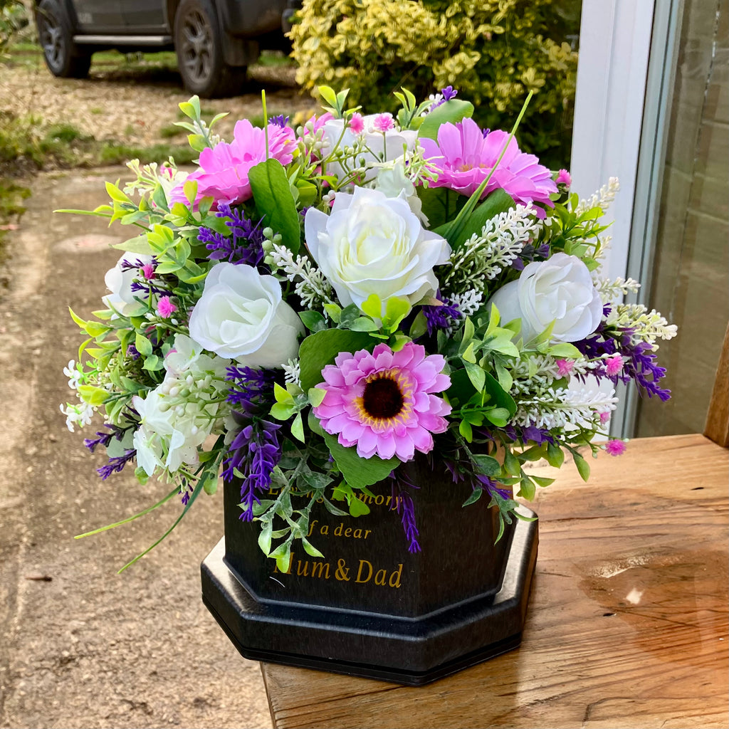 a graveside artificial flower arrangement in shades of cream and pink