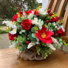 A Christmas artificial flower arrangement in hessian bag