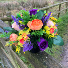 a grave pot with flowers featuring  artificial silk blooms