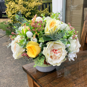 a grave pot with flowers featuring  artificial silk blooms