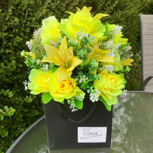 flower arrangement of artificial roses and lilies in black box