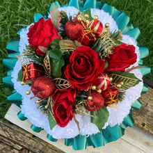 A christmas graveside memorial posy of red roses and carnations