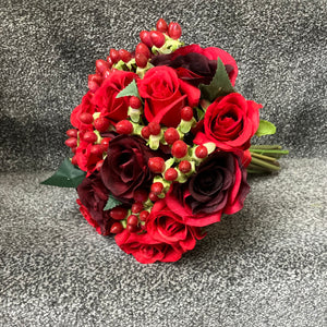 a wedding bouquet of red and burgundy silk roses & hypericum