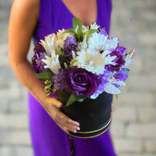 A flower arrangement in black hat box