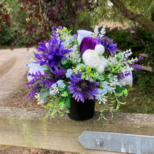 a grave pot with white artificial silk cornflowers and rose blooms