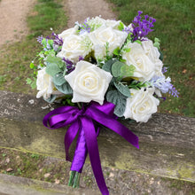 A wedding bouquet of artificial ivory roses & lavender flowers