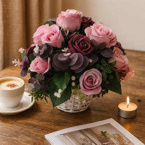 flower arrangment of artificial silk  pink and burgundy roses with a cup of coffee and candle on a wooden table.