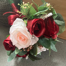 A wedding bouquet of artificial pink and burgundy roses