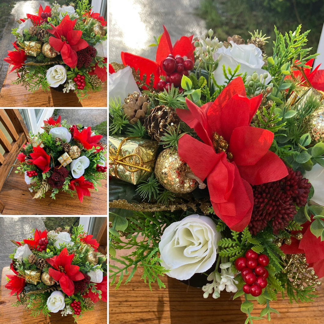 A Christmas red and gold memorial  arrangement in black pot