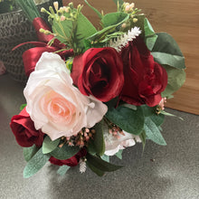 A wedding bouquet of artificial pink and burgundy roses