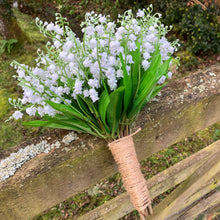 A wedding bouquet of pure white artificial lily of the valley flowers