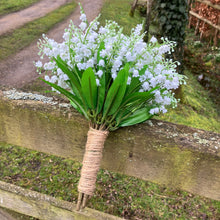 A wedding bouquet of pure white artificial lily of the valley flowers