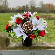 A memorial Christmas flower rose and poinsettia arrangement