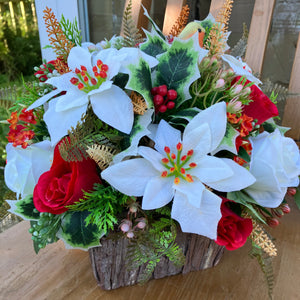 A Christmas artificial flower arrangement in rustic wooden container