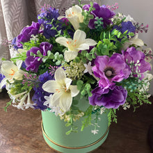A handtied arrangement of purple and ivory flowers & foliage