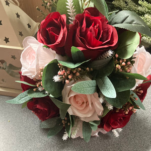 A wedding bouquet of artificial pink and burgundy roses