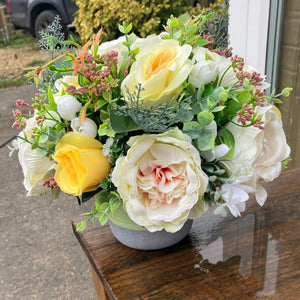 a grave pot with flowers featuring  artificial silk blooms