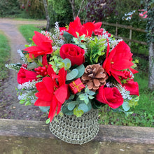 A Christmas artificial flower arrangement in knitted jute bag