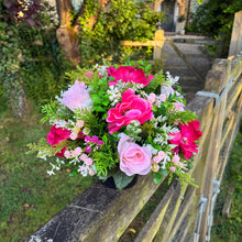 a graveside pink and cream memorial arrangement in black plastic pot
