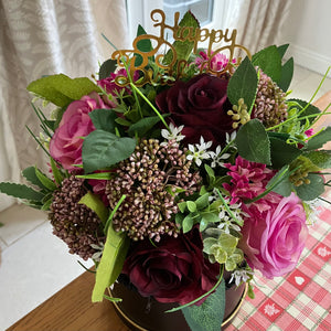 A flower arrangement in black hat box