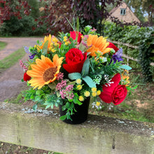 A graveside flower arrangement in black pot
