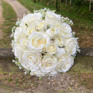 A wedding bouquet of artificial faux silk roses edged with Gypsophila