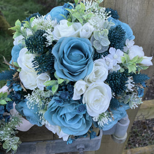 A wedding bouquet collection of ivory and teal flowers and foliage