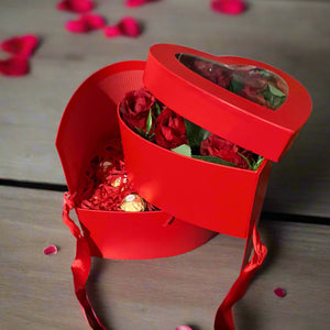 A Flower arrangement of red faux silk roses and ferrero rocha in red heart box