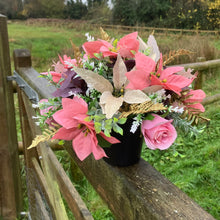 A Christmas graveside flower arrangement in black pot