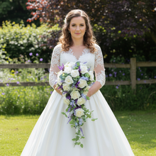 A wedding bouquet of artificial ivory roses & lavender flowers