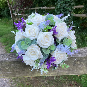A wedding bouquet of artificial ivory roses & lavender flowers