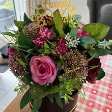 A flower arrangement in black hat box