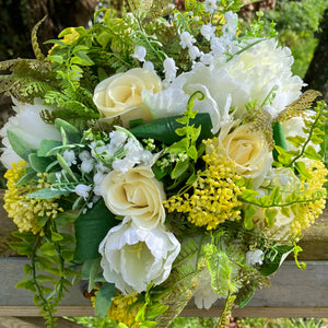 A brides bouquet of roses, peonies and fern