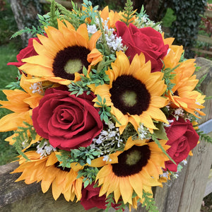 a wedding bouquet featuring artificial red roses, gyp & sunflowers