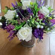 a flower arrangement of mauve & ivory roses, orchids and foliage