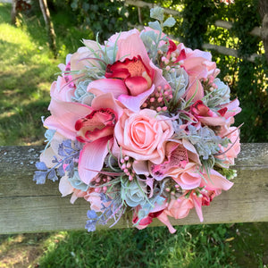 A wedding bouquet of coral and grey artificial roses and orchids