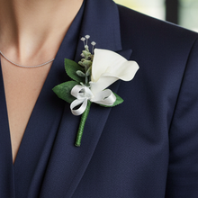 A buttonhole of a white real touch calla lily and bow