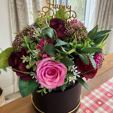 A flower arrangement in black hat box