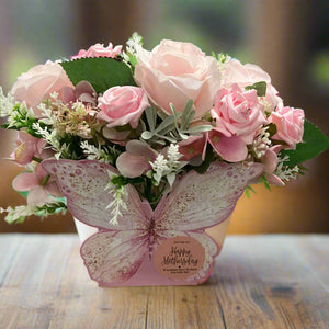 a arrangement of artificia pink flowers in butterfly container