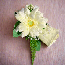 an artificial wedding corsage featuring a rose and gerbera with foliage