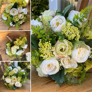 A brides bouquet of roses, ranunculus and fern