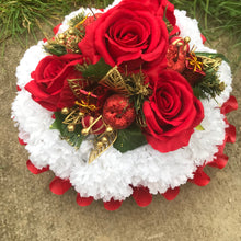 A christmas graveside memorial posy of red roses and carnations