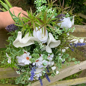 A brides bouquet of white calla, roses, lavender and foliage