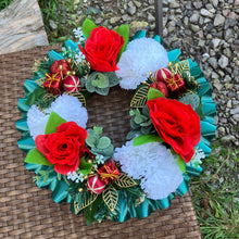 A christmas graveside memorial wreath of red roses and carnations
