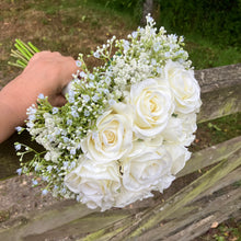A wedding bouquet of artificial faux silk roses edged with Gypsophila