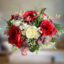 a flower arrangement of red & ivory roses