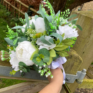 a large wedding bouquet of white roses and peonies