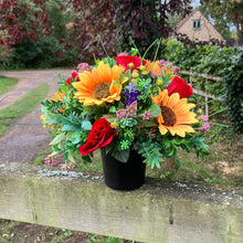 A graveside flower arrangement in black pot