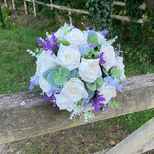 A wedding bouquet of artificial ivory roses & lavender flowers