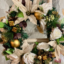 An artificial pine christmas wreath with pale gold and ivory decorations